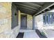 Covered front porch featuring stone accents, a modern light fixture, and a gray front door at 660 Sun Valley Ct, Indianapolis, IN 46217