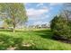 Scenic backyard view overlooking the community pond, featuring a lush green lawn and mature trees at 6625 W Winding Bnd, McCordsville, IN 46055