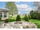Backyard with a stone fire pit and beautiful landscaping, perfect for outdoor gatherings at 6625 W Winding Bnd, McCordsville, IN 46055