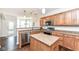 Well-lit kitchen featuring stainless steel appliances, an island, and hardwood flooring at 6625 W Winding Bnd, McCordsville, IN 46055