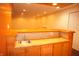 Finished basement bar area with wooden cabinetry, lighting, sink, and tile backsplash at 6725 Tramcus Dr, Indianapolis, IN 46260