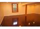 Spacious finished basement showcasing hardwood flooring, natural light, and a support beam at 6725 Tramcus Dr, Indianapolis, IN 46260