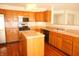 The kitchen features wood cabinets, stainless steel appliances, a center island and hardwood floors at 6725 Tramcus Dr, Indianapolis, IN 46260