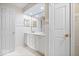 Bright, white bathroom features a double sink vanity and neutral tiling accents at 7424 Prairie Lake Dr, Indianapolis, IN 46256
