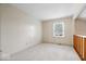 Neutral bedroom with a large window, carpet flooring, and wooden railing at 7424 Prairie Lake Dr, Indianapolis, IN 46256