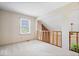 Neutral bedroom with a large window, carpet flooring, and wooden railing at 7424 Prairie Lake Dr, Indianapolis, IN 46256
