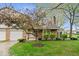 Charming two-story home with a well-maintained lawn, mature flowering tree, and attached garage at 7424 Prairie Lake Dr, Indianapolis, IN 46256