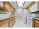 Functional kitchen features light wood cabinetry, white appliances, and tile flooring at 7424 Prairie Lake Dr, Indianapolis, IN 46256