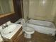 Compact bathroom featuring a standard tub, toilet, and sink with wood-look flooring at 100 N Blue River Dr, Edinburgh, IN 46124