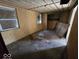 Bedroom with plywood walls, two windows and stained concrete floors at 100 N Blue River Dr, Edinburgh, IN 46124