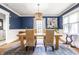 Elegant dining room featuring hardwood floors, a wooden table, woven chairs, and large windows at 1044 E Garfield Dr, Indianapolis, IN 46203