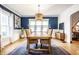 Bright dining room with blue accent wall, wainscoting, stylish chandelier, and hardwood floors at 1044 E Garfield Dr, Indianapolis, IN 46203