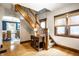 Bright foyer featuring hardwood floors, staircase with wood banister, and natural light from the window at 1044 E Garfield Dr, Indianapolis, IN 46203