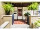 Inviting front door with decorative glass, brick details, and hanging ferns create a warm welcome at 1044 E Garfield Dr, Indianapolis, IN 46203