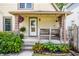 Charming front porch adorned with greenery, hanging plants, and a cozy bench seating area at 1044 E Garfield Dr, Indianapolis, IN 46203