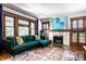 Comfortable living room with a fireplace, mantel, tile details, and a plush green sofa with pillows at 1044 E Garfield Dr, Indianapolis, IN 46203