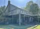 Rear of the log cabin, highlighting the elevated deck and stone chimney at 10770 W 650 S, Columbus, IN 47201