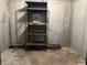A dirty, unfinished basement with metal racking and a small safe at 10770 W 650 S, Columbus, IN 47201