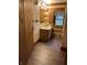 Rustic bathroom featuring log walls, window with nature view, and wood-look floors at 10770 W 650 S, Columbus, IN 47201