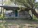 Exterior view of a charming cabin with a porch, surrounded by trees and greenery at 10770 W 650 S, Columbus, IN 47201