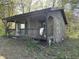 Exterior of a rustic cabin featuring a covered porch and natural setting at 10770 W 650 S, Columbus, IN 47201