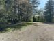 Gravel driveway leading to a wooded property under a blue sky at 10770 W 650 S, Columbus, IN 47201