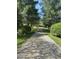 Long gravel driveway leading to the property surrounded by tall trees and lush greenery at 10770 W 650 S, Columbus, IN 47201