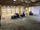 Garage interior with an open ceiling and unfinished concrete floor at 10770 W 650 S, Columbus, IN 47201