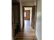 Hallway with wood floors leading to a bathroom and other rooms at 10770 W 650 S, Columbus, IN 47201