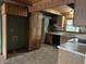 Kitchen featuring wooden cabinets, green walls, and a view into a neighboring room at 10770 W 650 S, Columbus, IN 47201