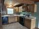 Kitchen with wooden cabinets, black appliances, and view of the outdoors at 10770 W 650 S, Columbus, IN 47201
