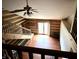 An eye-level shot of a living room featuring wood flooring, log walls, a ceiling fan, and a staircase at 10770 W 650 S, Columbus, IN 47201