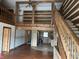 Open-concept living room with log beams, wood floors, and a view into the kitchen at 10770 W 650 S, Columbus, IN 47201