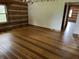 Open living room with hardwood floors, log walls, and natural light at 10770 W 650 S, Columbus, IN 47201