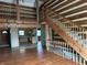 Open-concept living space with a wooden staircase and a glimpse into the rustic kitchen at 10770 W 650 S, Columbus, IN 47201
