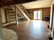 Spacious living room featuring log walls, hardwood floors, and natural light from a sliding door at 10770 W 650 S, Columbus, IN 47201