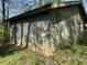 Exterior view of an outbuilding with weathered siding and overgrown surroundings at 10770 W 650 S, Columbus, IN 47201