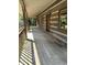 Long, covered wooden porch showing rustic log cabin details and exterior lighting at 10770 W 650 S, Columbus, IN 47201