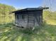 Vintage cabin-style shed beside a tranquil pond, ideal for outdoor storage at 10770 W 650 S, Columbus, IN 47201