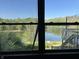 Window view of lake surrounded by lush greenery, under a clear blue sky at 10770 W 650 S, Columbus, IN 47201