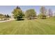 Expansive green lawn extending towards the street, surrounded by lush trees and neighborhood homes at 11124 Winterwood Dr, Indianapolis, IN 46235