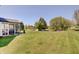 Beautifully landscaped backyard featuring a spacious lawn, mature trees, and a screened-in porch at 11124 Winterwood Dr, Indianapolis, IN 46235