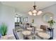 Open-concept view of a dining room with a glass table adjacent to a living room with sectional at 11124 Winterwood Dr, Indianapolis, IN 46235