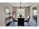 Dining room features a glass table, stylish chandelier, and a mirrored accent piece at 11124 Winterwood Dr, Indianapolis, IN 46235