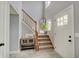 Open foyer with wooden staircase, stylish decor, a gray accent walls, and a bright entry door at 11124 Winterwood Dr, Indianapolis, IN 46235