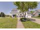 Charming two-story white home featuring a well-manicured lawn and inviting covered front porch with black accents at 11124 Winterwood Dr, Indianapolis, IN 46235