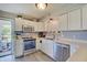 Well-lit kitchen features white cabinetry, stainless steel appliances, and backyard access at 11124 Winterwood Dr, Indianapolis, IN 46235