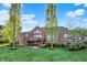 Gorgeous brick home featuring a spacious backyard, mature trees, and a charming outdoor patio area at 11341 Abercairn Ct, Zionsville, IN 46077