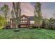 Charming backyard with a brick home, lush lawn, deck, and mature trees at 11341 Abercairn Ct, Zionsville, IN 46077