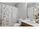 Well-lit bathroom featuring a floral shower curtain, toilet, and sink with a vanity at 11341 Abercairn Ct, Zionsville, IN 46077